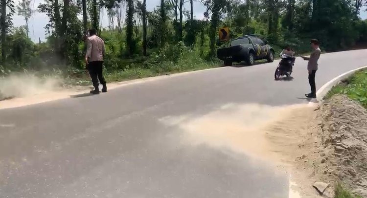 Peduli Keselamatan Pengendara, Polisi Bersihkan Pasir di Jalinsum Way Kanan