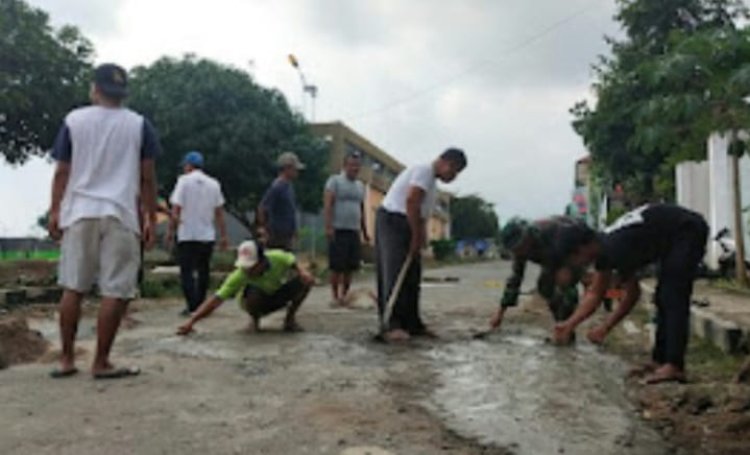 Melalui Swadaya, Babinsa dan Warga Tiuh balak pasar Perbaiki Jalan yang berlubang